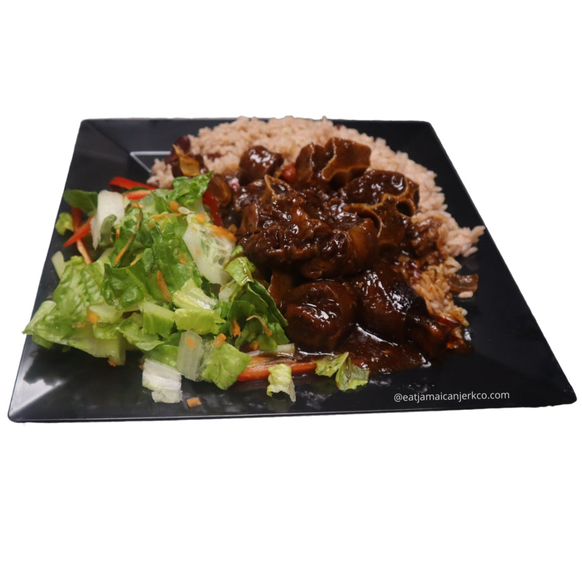 Square black plate with oxtail, rice, and salad on a white background