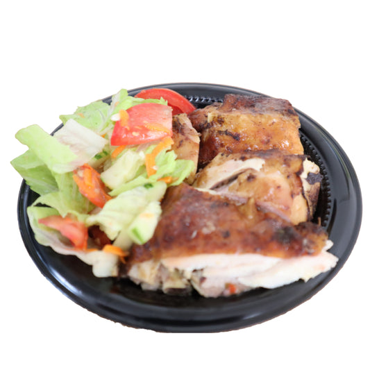Plated dish with roasted chicken and a side salad on a white background